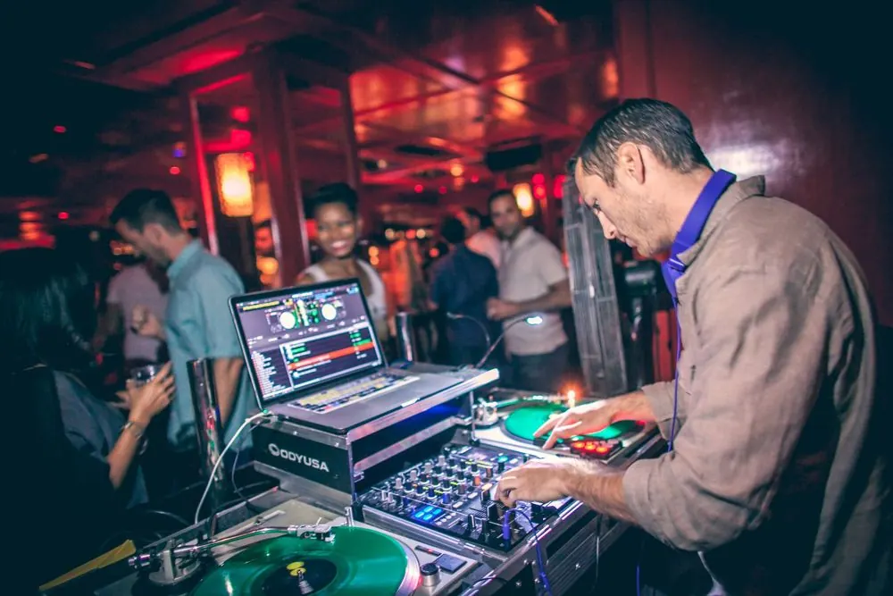 DJ Maple Syrup mixing live at a crowded corporate event